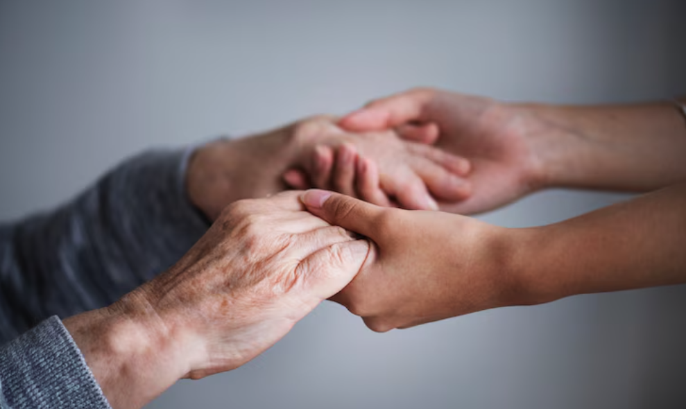 Carer holding hands with person with dementia